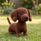 A brown crocheted dachshund-style dog toy sits on green grass outdoors, with a blurred garden background and the text 'STYLE 3' in the upper left corner.