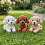 Three crocheted plush puppy toys in white, brown, and cream are sitting on a green grassy lawn with a blurred garden background.