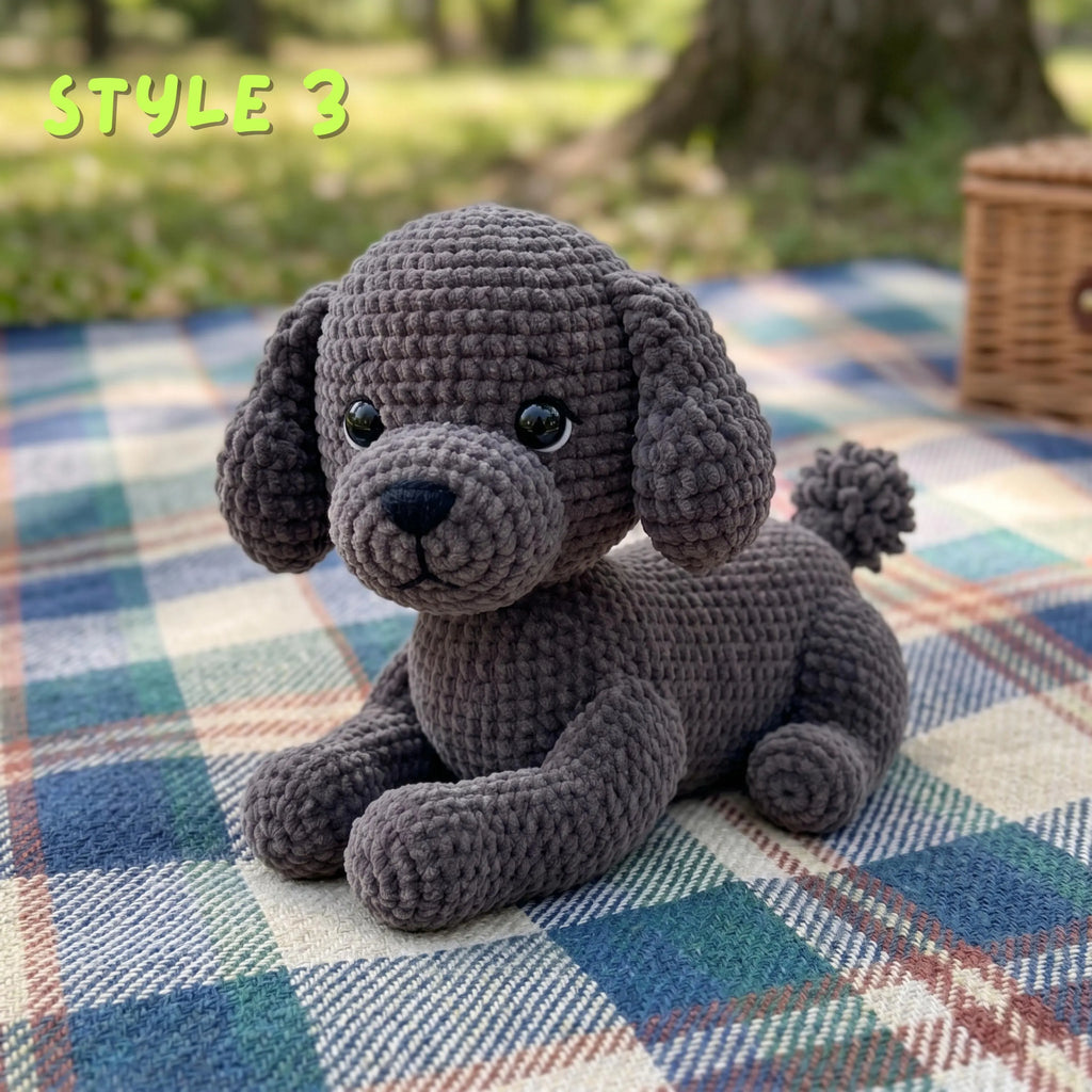 A crocheted plush puppy toy in dark gray sits on a blue, green, and white plaid blanket outdoors, with blurred trees in the background and the text 'STYLE 3' in the top left corner.